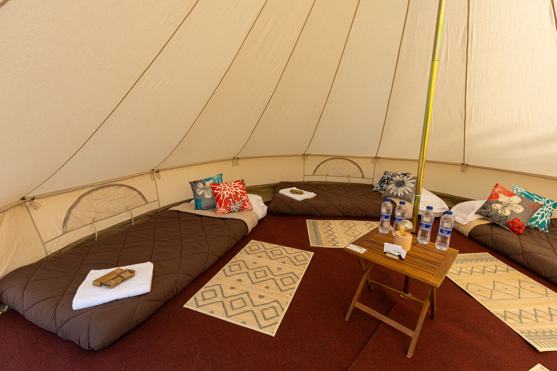 Interior d'un tipi amb llits i coixins
